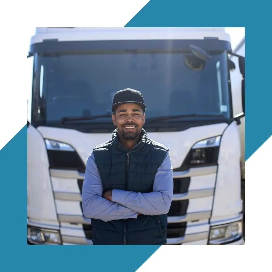 Smiling truck driver standing in front of a truck