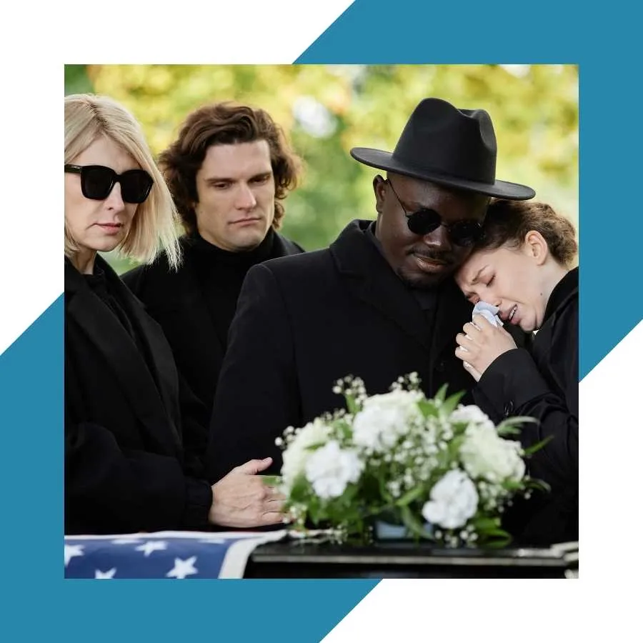Mourners at a funeral, grieving by a casket with flowers