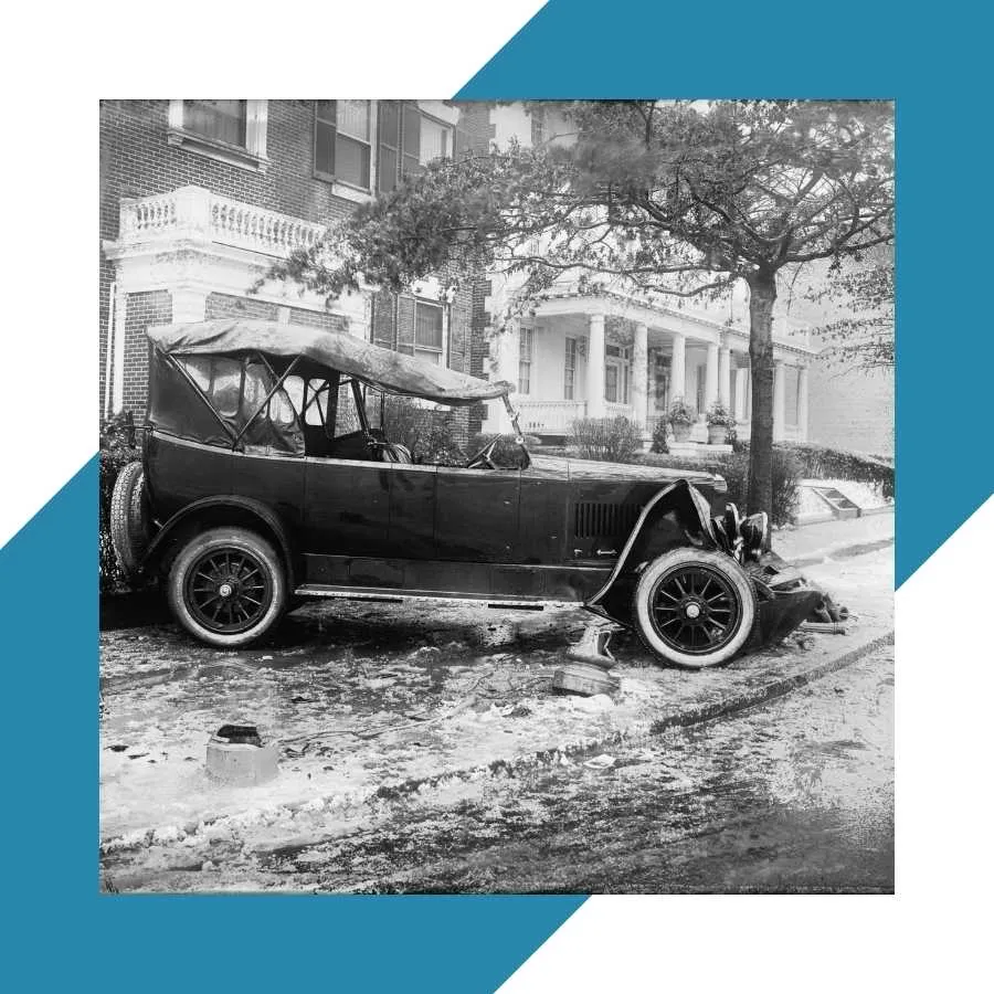 Vintage car crash scene in front of residential buildings