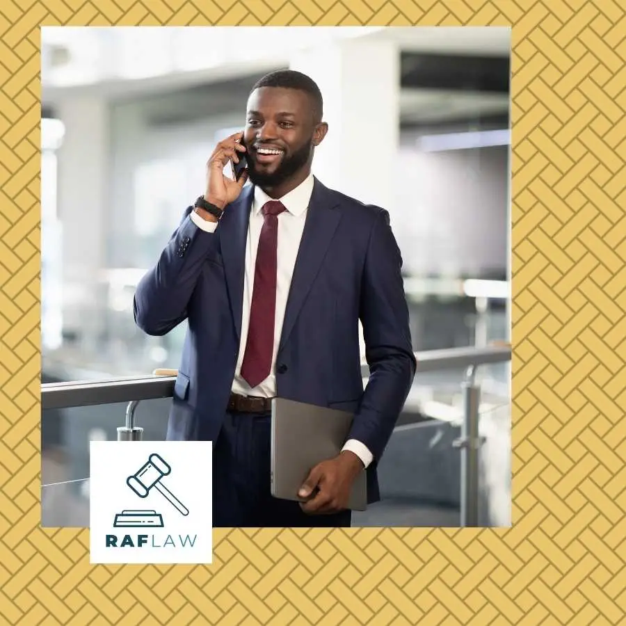 Confident attorney on a phone call holding documents with the RAF LAW logo, representing professional legal consultation