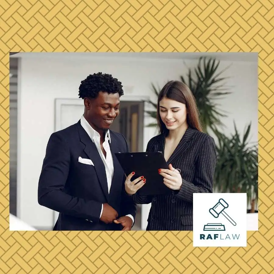 Two legal professionals reviewing a document together with the RAF LAW logo, symbolizing collaborative legal consultation.