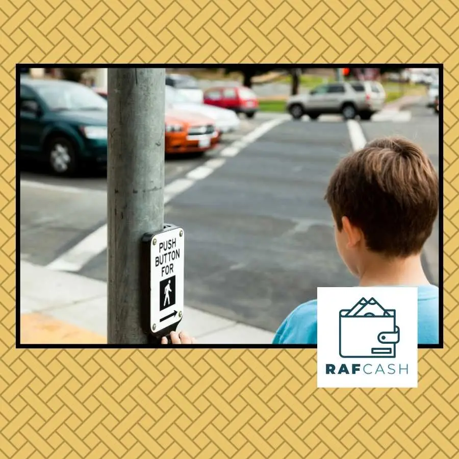 Young boy at a pedestrian crossing, about to push the crosswalk button, with moving cars in the background and the RAFCASH logo displayed.