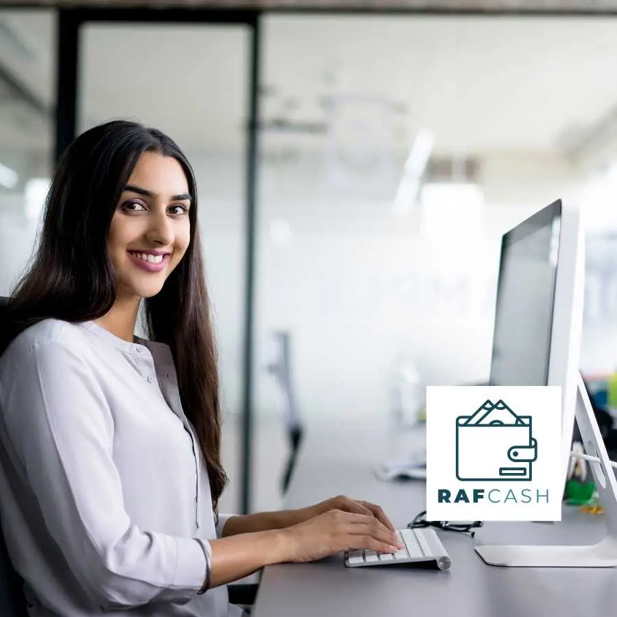 Professional Woman Confidently Working on Computer in Modern Office Setting with RAF Cash Branding