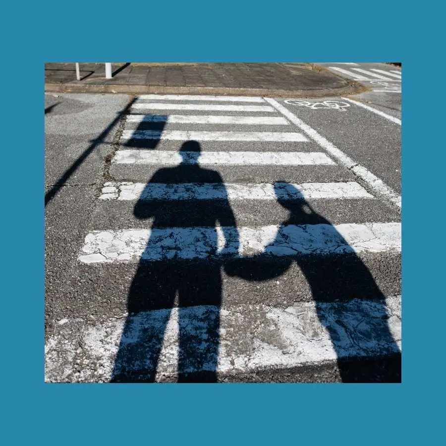Shadows of Two People Holding Hands While Crossing the Street