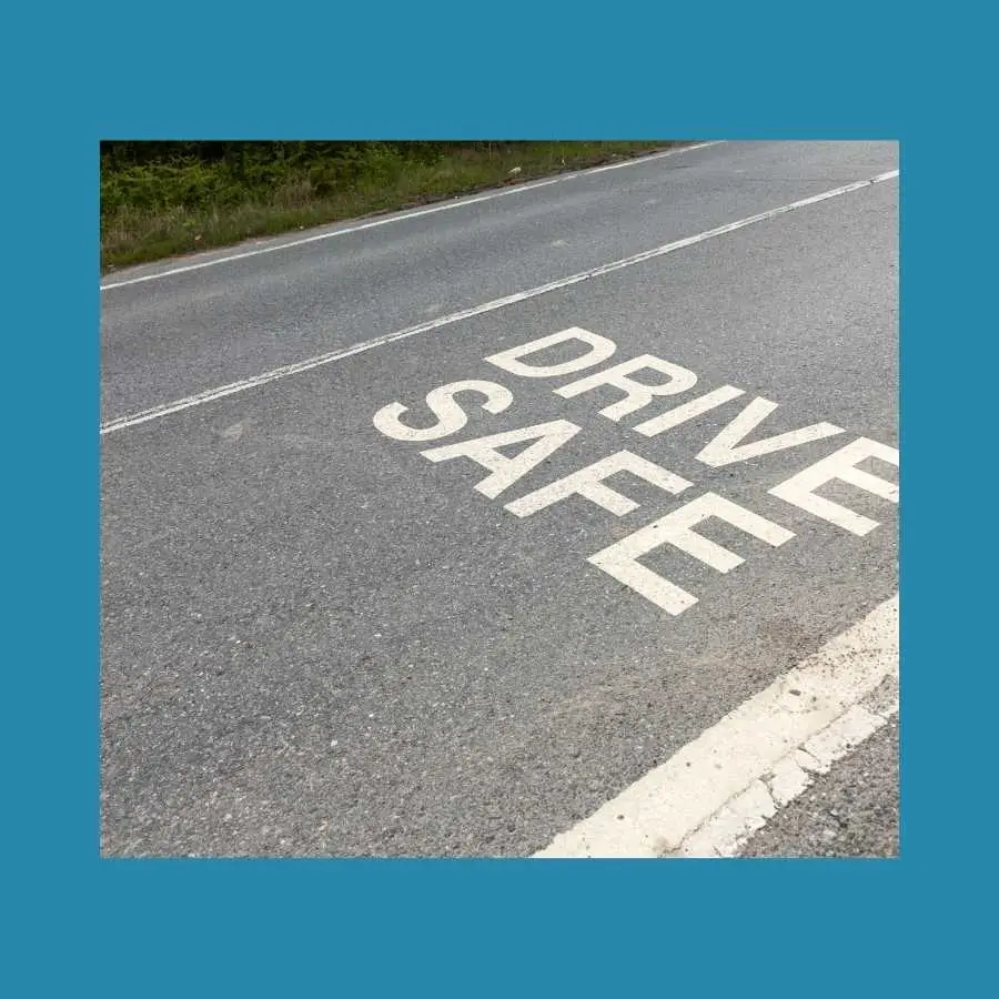 Road with "DRIVE SAFE" painted message reminding drivers of road safety
