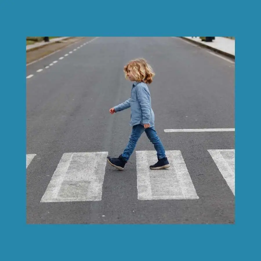Child crossing the road on pedestrian crossing