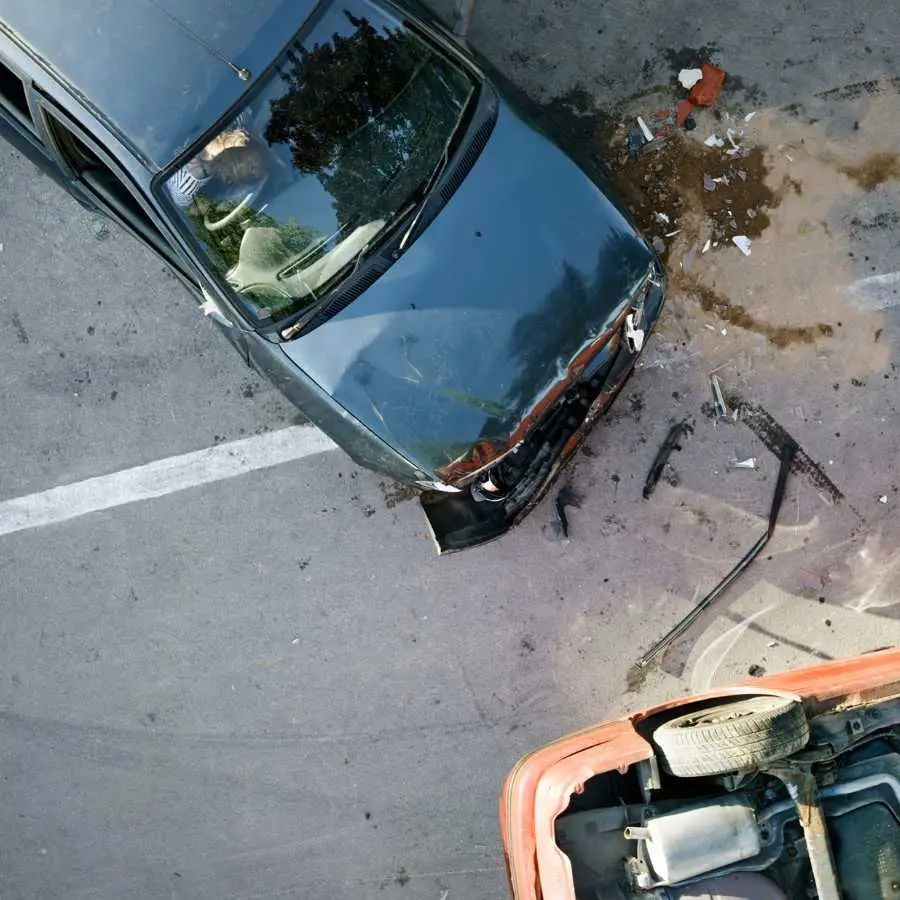 Overhead view of a car accident with visible damage and debris on the road.