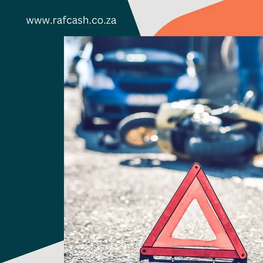 Warning triangle in focus with a blurred background showing a motorcycle accident and car