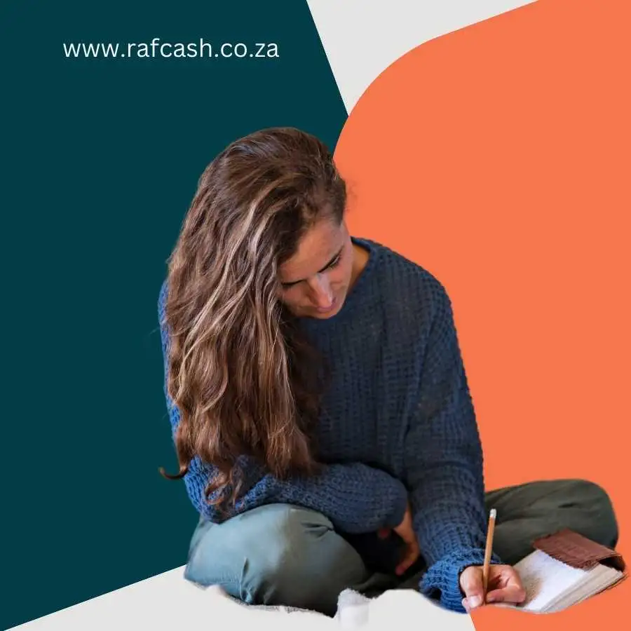 Woman in a blue sweater writing on paper while sitting on the floor