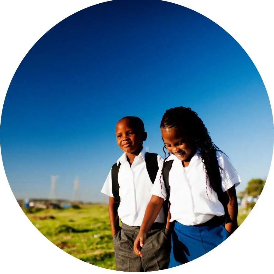 Two young students walking to school in a rural area