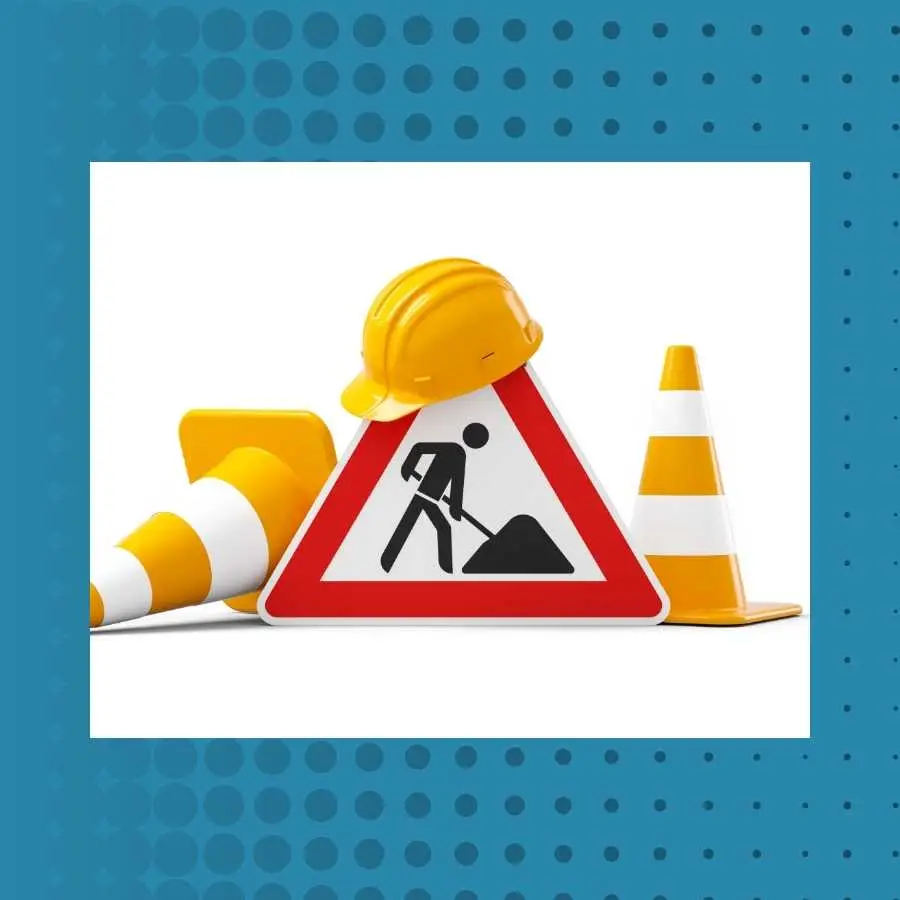 Road construction sign with helmet and traffic cones