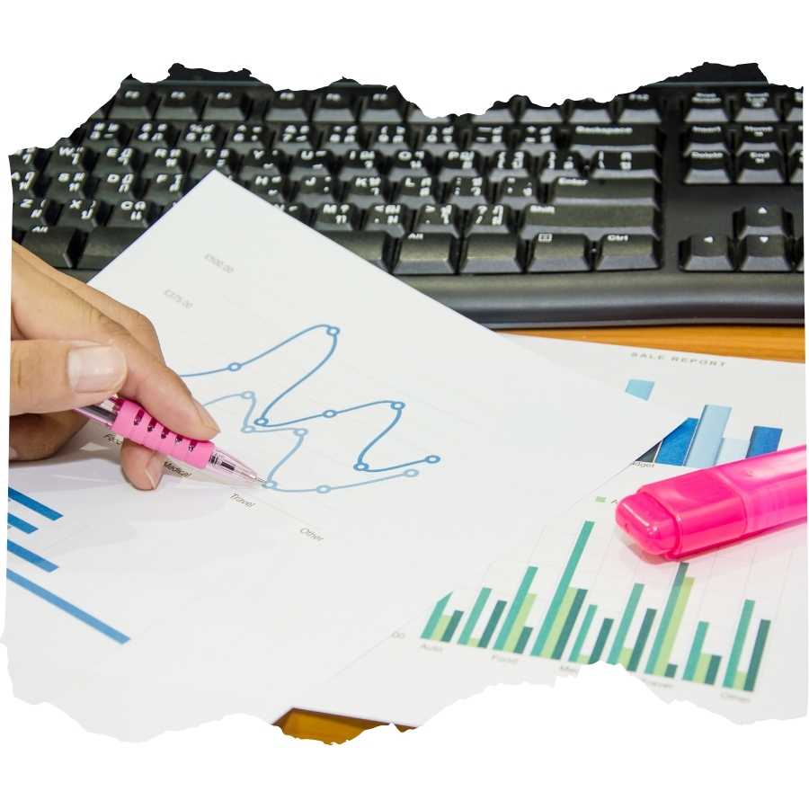 Hand highlighting trends on an economic report with a pink highlighter