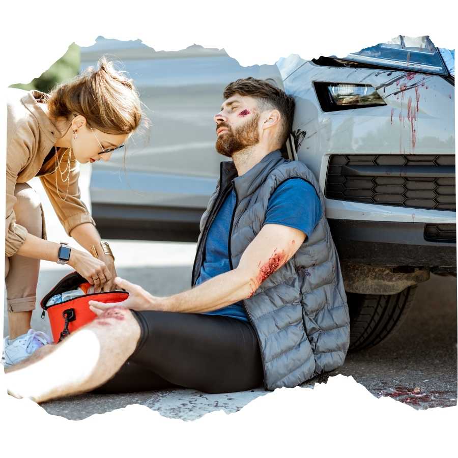 Immediate roadside first aid being administered to a man with injuries after a car accident