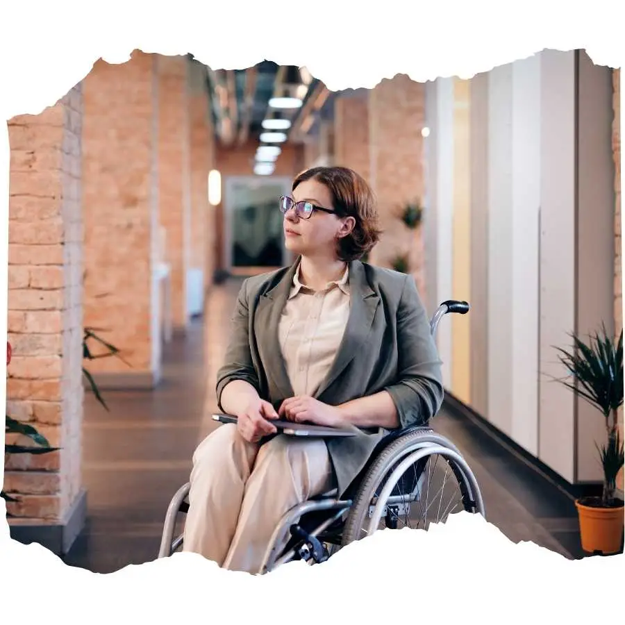 Professional woman in a wheelchair navigating an office corridor