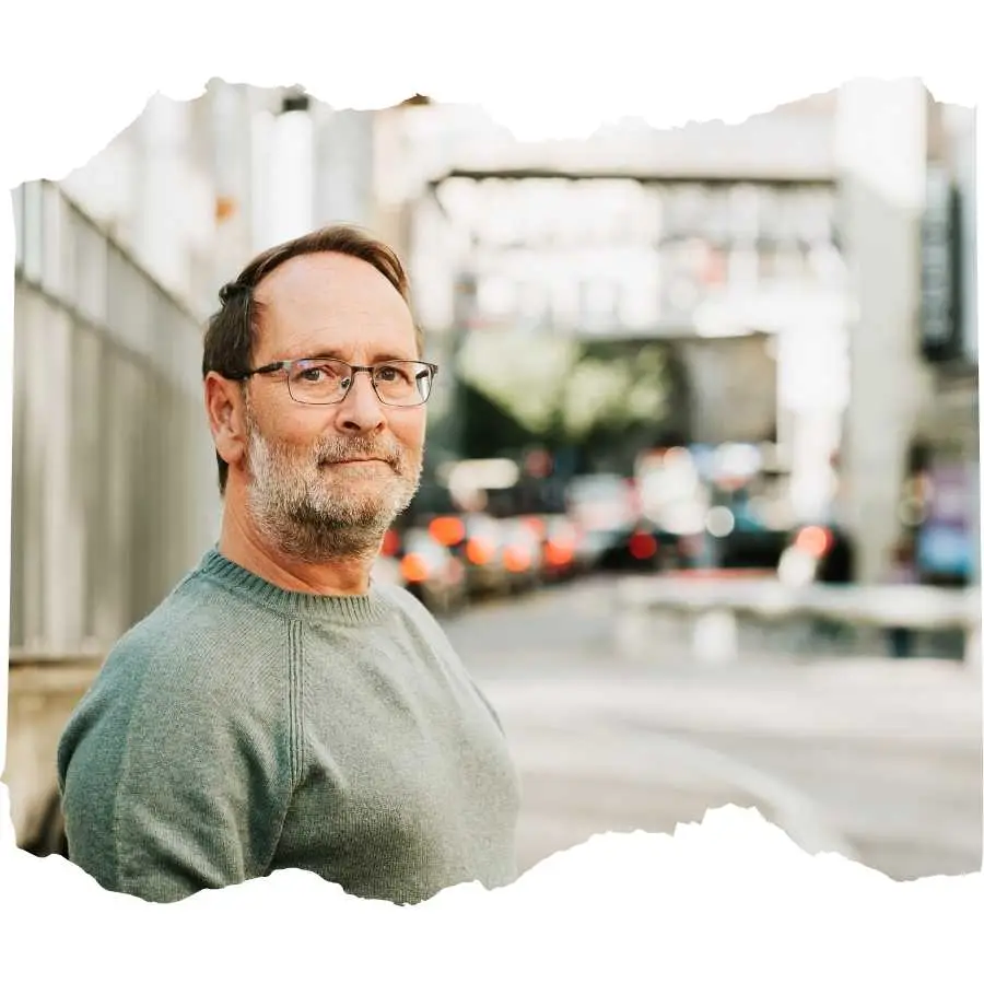 Middle-aged man in casual wear smiling on a city street