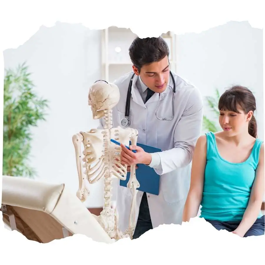 Doctor explaining skeletal anatomy to a patient using a human skeleton model