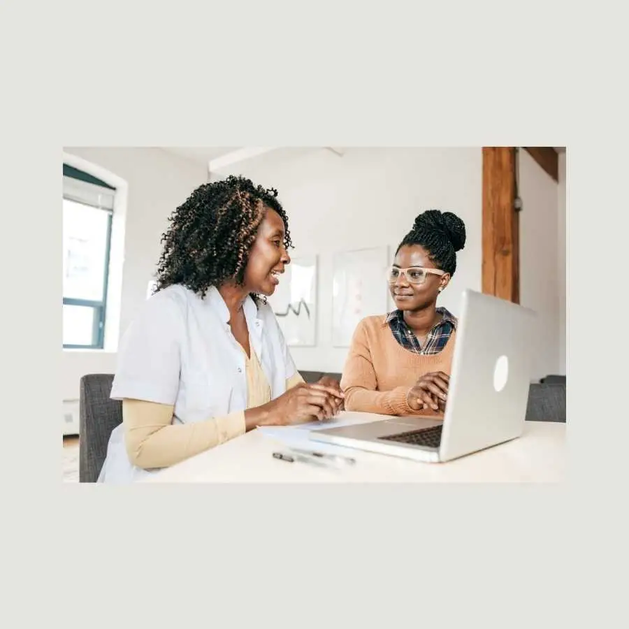 Healthcare professional discussing medical details with a patient using a laptop