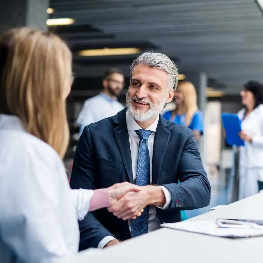 Lawyer shaking hands with a doctor in a hospital setting