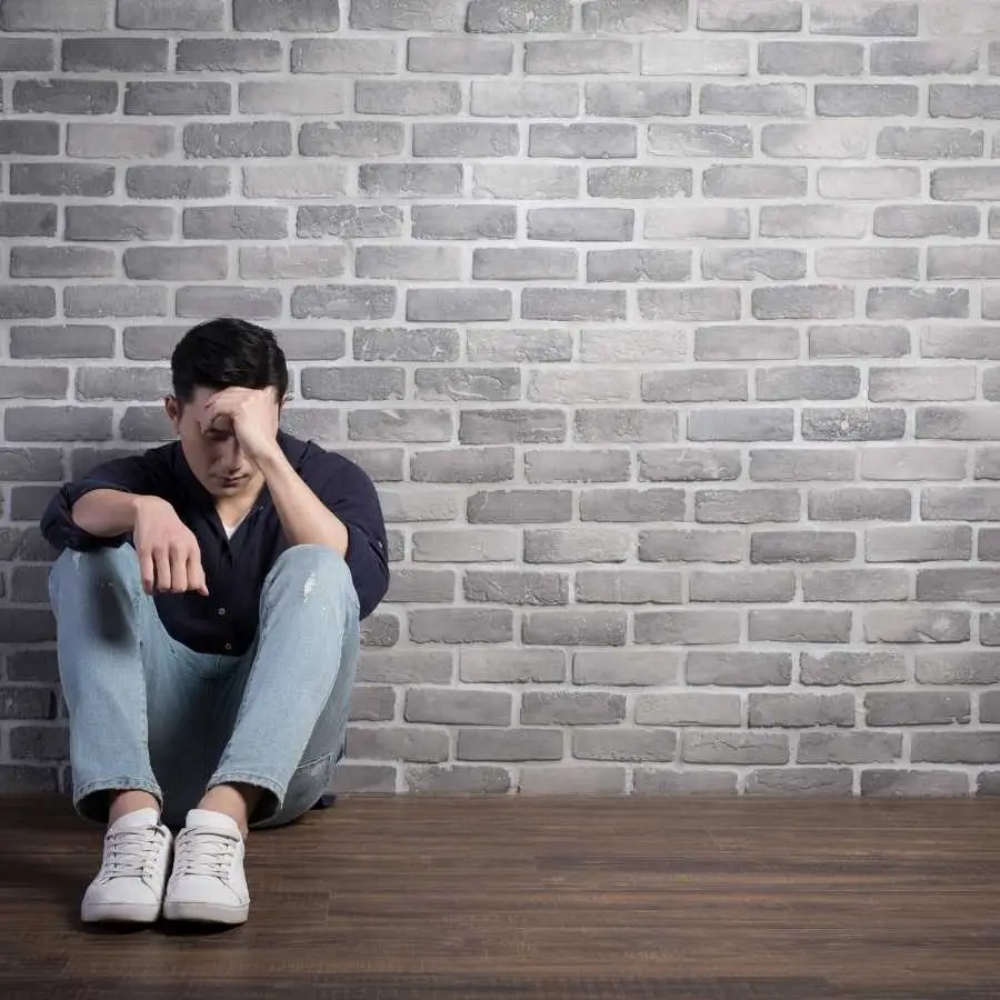 Man Sitting on Floor in Despair