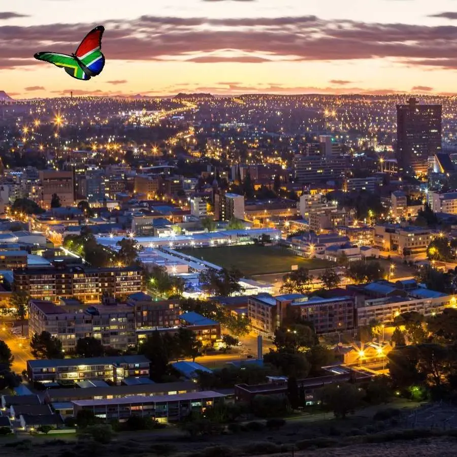 Night view of Bloemfontein city with a South African flag-themed butterfly