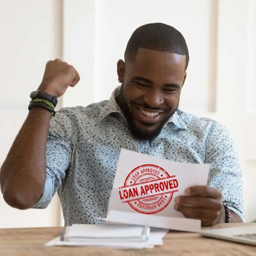 Man celebrating loan approval with a stamped document