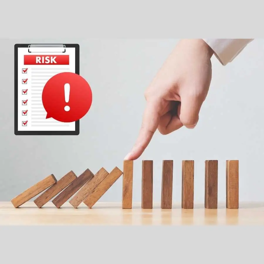 Hand stopping falling dominoes with risk checklist symbol