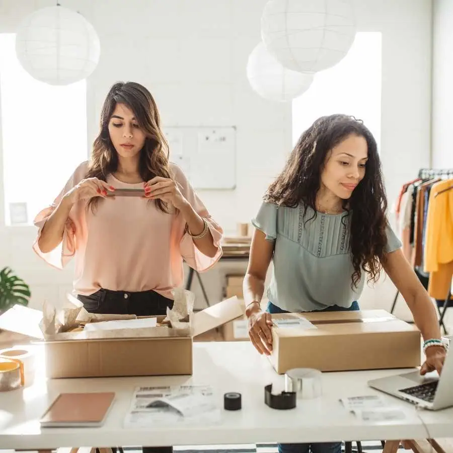 Two women packing products for shipping in a small business office