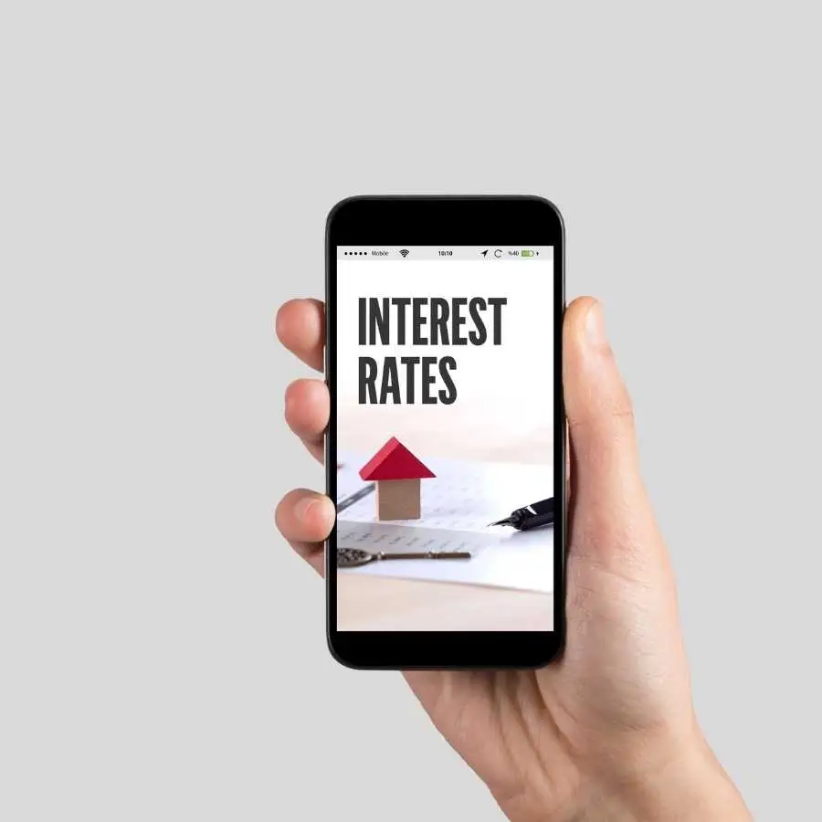 Hand holding a smartphone displaying interest rates for bridging loans