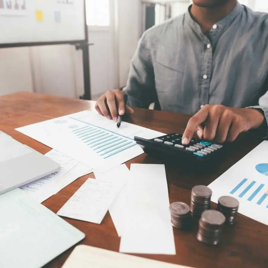 Person Calculating Financials with Calculator and Documents